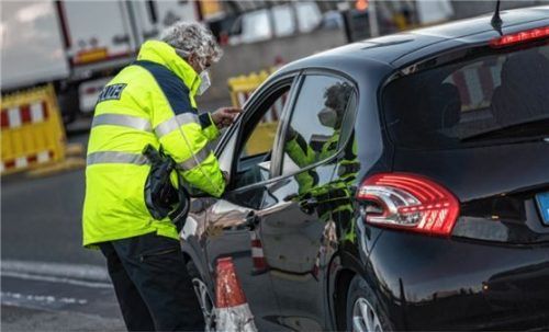 Ein Bundespolizist kontrolliert an der Grenze die Insassen eines Fahrzeugs. Foto Bundespolizei