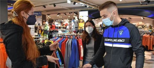 Geimpft oder Genesen? Tessa Irlbacher, Geschäftsführerin des Raublinger Sportgeschäfts Iko, kontrolliert zusammen mit ihrem Mitarbeiter Daniel Klarner den Nachweis von Kundin Sabine Asenbeck. Foto Ruprecht