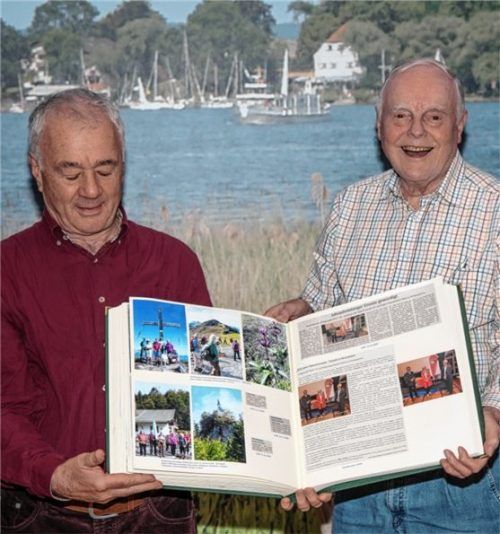 Vorsitzender Albin Stieber (links) bekommt von Ferdinand Esser die aktualisierte Chronik überreicht. Foto re