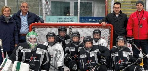 Auf der Eisfläche: (von links) Familie Werzinger, Gründungsmitglied der Rosenheimer Unterstützungskasse und Mitbegründer der RobAV GmbH, gemeinsam mit Daniel Bucheli, Geschäftsführer der Starbulls Rosenheim, und Rick Böhm, U20-Headcoach der Starbulls Rosenheim, sowie einigen Starbulls-Spielern. Foto Starbulls Rosenheim