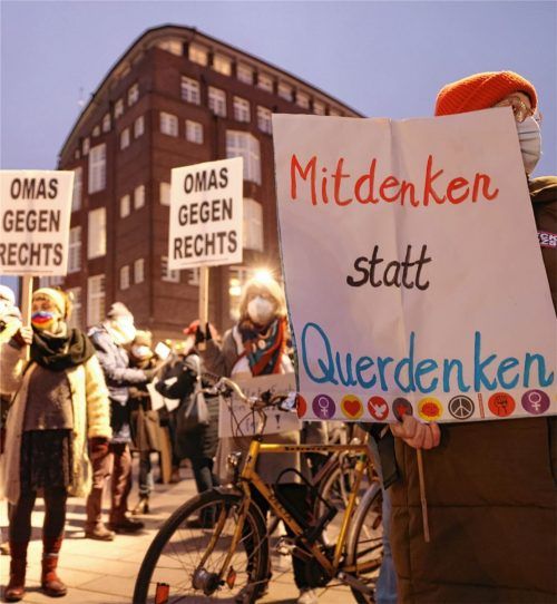 Demonstranten halten Plakate mit den Aufschriften „Mitdenken statt Querdenken“ und „Omas gegen Rechts“ bei einer Demonstration für die Einhaltung der Corona-Regeln. Foto dpa