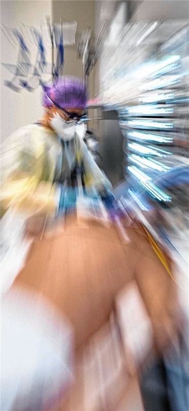 Ein Krankenpfleger versorgt in einer Klinik einen Covid-19-Patienten. Doch auch nach erfolgreicher Behandlung kämpfen die Erkrankten oftmals noch lange Zeit mit körperlichen Auswirkungen der Infektion. Foto dpa