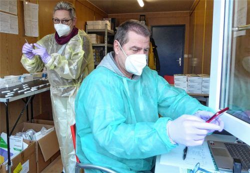 Testen mit Schutzanzügen, Handschuhen und Masken: Johanna Arnold wertet die Proben aus, während Burkhard Gogalla schon die nächste Person eincheckt. Foto Riediger