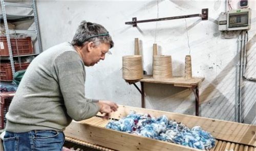 Viel Handarbeit: Christian Edenhofer legt farbige Wolle zur Erstellung eines Wollgarns auf.