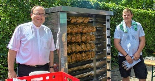 Beim Pfarrfest zum Mitnehmen Dekan Klaus Vogl (links) vor dem Hendl-Grill. Foto Bernd Klemmer