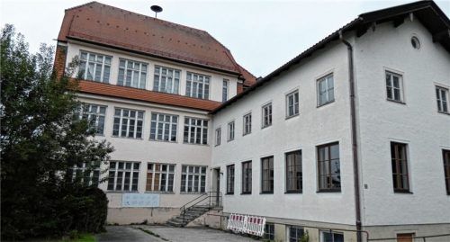 Das alte Erlstätter Schulhaus, das unter Denkmalschutz steht (links, der Anbau rechts aus den 1950er-Jahren könnte schon im Sommer weggerissen werden) soll im Rahmen der Städtebauförderung saniert werden. Nach dem Abschluss der aufwendigen Baumaßnahmen werden dort unter anderem die Pfarrei, die Ortsvereine und die Jugend unterkommen.