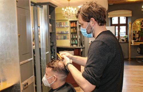 Der Rosenheimer Friseur Phillip Louys mit einem Kunden. Auch in seinen Salon kommen immer mehr Männer, die ihren Körper jenseits des Harrschnittes pflegen lassen. Foto Biber