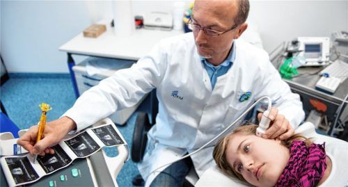 Ein Arzt untersucht ein junges Mädchen, das im Alter von zehn Monaten einen Schlaganfall erlitten hat. Foto Bernd Thiessen/dpa
