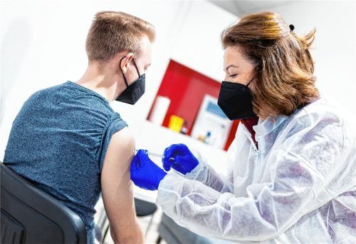 Ein junger Mann wird gegen das Coronavirus geimpft. Die verwendeten Impfstoffe sorgen auch nach milliardenfacher Verwendung für gespaltene Gemüter. Foto dpa