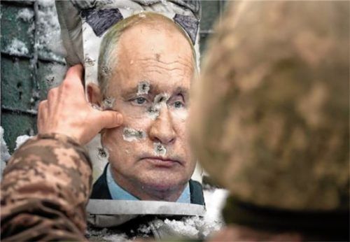 Ein ukrainischer Soldat justiert ein von Kugeln durchlöchertes Bild des russischen Präsidenten Putin. Foto dpa