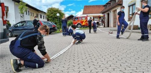 Unter Einhaltung der Hygiene-Vorschriften übte der Gries-stätter Feuerwehr-Nachwuchs vor dem Rathaus, Schläuche einzurollen und zu verlegen.