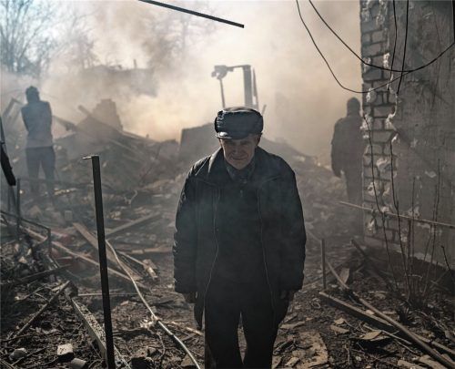 Ein Mann steht inmitten des Rauchs eines brennenden Hauses, das nach einem russischen Angriff in Charkiw zerstört wurde. Foto dpa