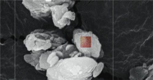Eine Nahaufnahme des Sandkorns zeigt die feine Oberflächenstruktur des Wüstenstaubs.