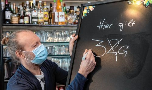 Gastronom Jörg Hicker passt eine Informationstafel in seiner „Ansprechbar“ an.Foto dpa
