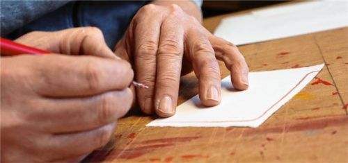 Mit roter Tusche entsteht Kästchen für Kästchen ein neues Kunstwerk.