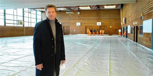 Schutz für Menschen aus der Ukraine: Andreas Schaller, Leiter des Ludwig-Thoma-Gymnasiums in Prien, beobachtet, wie Bauhofmitarbeiter die Schulsporthalle als Unterkunft vorbereiten. Foto Berger