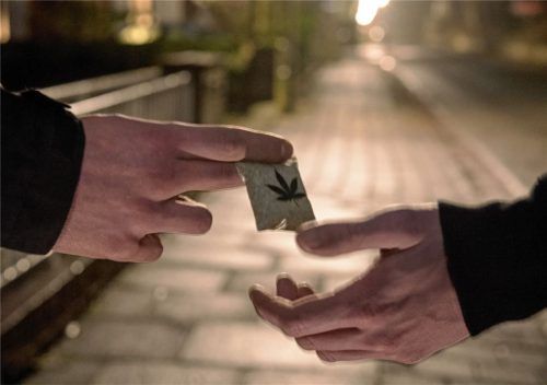 Ein Drogendealer übergibt auf diesem Symbolfoto einem Käufer ein Päckchen mit Marihuana. In Traunstein stehen derzeit vier Männer vor Gericht, weil sie die Schulden eines damals 17-Jährigen aus einem Drogengeschäft gewalttätig eingetrieben haben sollen. Foto dpa