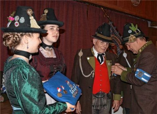 Franz Steinkirchner (Mitte) wird von Hauptmann Sepp Stadler für 40 Jahre aktiven Dienst ausgezeichnet. Mit auf dem Bild (von links) die Marketenderinnen Veronika Paul und Madalena Hoffmann. Foto Re