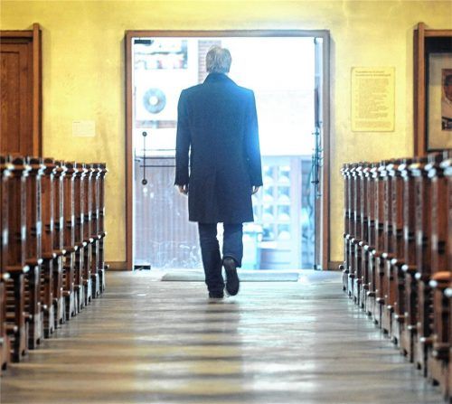 In dieser symbolisch nachgestellten Szene verlässt ein Mann eine katholische Kirche. Foto dpa