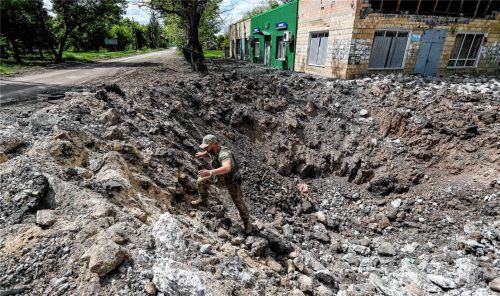 Ein ukrainischer Soldat einer Aufklärungseinheit begutachtet ein riesiges Loch, das durch einen russischen Luftangriff am Rande der Donbass-Region entstanden sein soll. Foto dpa