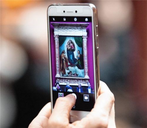 Eine Frau fotografiert das Gemälde „Sixtinische Madonna“ von Raffael. Foto dpa