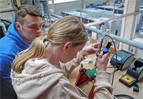 Girls Day bei Krause Industrieschaltanlagen in Raubling: Die 13-jährige Rosalie lötet unter der Aufsicht von Lehrling Andreas eine Herzplatine mit farbigen LEDs.Foto Sönmez
