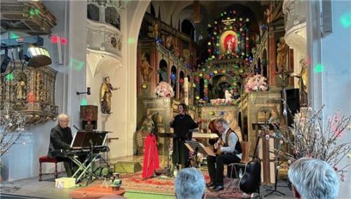 Jörg Florian Müller (Klavier und Akkordeon), Isabella Kaiser (Gesang) und Andi Reichhelm (Gitarre, von links) gestalteten vor dem Heiligen Grab in der Aschauer Pfarrkirche die Passion musikalisch.Foto Kirchner