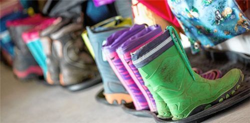Vollbesetzte Garderobe: Gummistiefel und Wechselklamotten stehen in einer Kita dicht an dicht. Foto DPA(Jens Büttner)