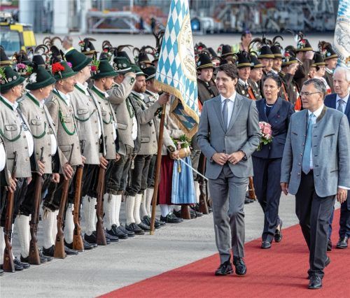 Bayerische Gebirgsschützen und Trachtler stehen Spalier zur Begrüßung der Gäste des G7-Gipfels: (von links im Vordergrund) Justin Trudeau, Premierminister von Kanada, und Florian Herrmann (CSU), Leiter der Bayerischen Staatskanzlei, am Flughafen München. Fotos RE(3)/picture alliance/dpa(2)