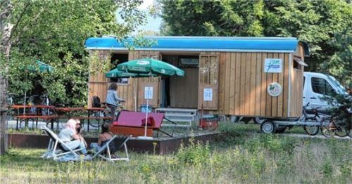 Der für Kultur- und Freizeitangebote umgestaltete Bauwagen steht bis Ende Juli gegenüber dem Schwimmbad. Dort treffen sich Menschen aus Rosenheim und der Ukraine. Foto re