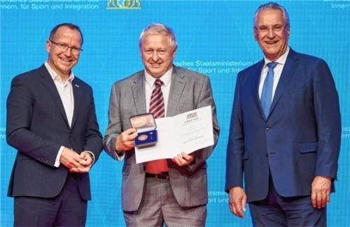 Der Präsident des Bayerischen Landessportverbandes Jörg Ammon (links) und Innenminister Joachim Herrmann (rechts) gratulieren Peter Eberl. Foto re
