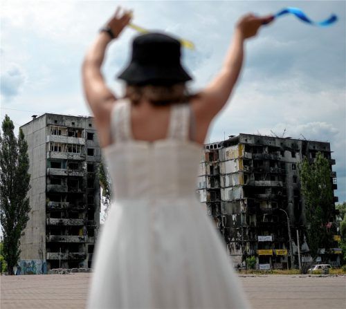 Ein Mädchen tanzt in der Nähe eines durch russische Angriffe zerstörten Gebäudes in Borodjanka am Stadtrand von Kiew. Foto dpa