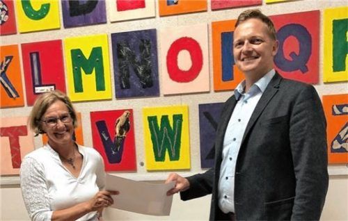 Beeindruckt nahm Bürgermeister Simon Frank den Scheck von Astrid Sauer, Direktorin der Preysing Grundschule Aschau, entgegen.
