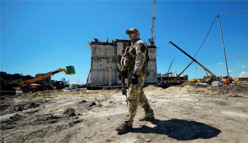 Ein russischer Soldat bewacht die Baustelle eines neuen Wohnblocks, der mit Unterstützung des russischen Verteidigungsministeriums in Mariupol gebaut wird. Foto dpa