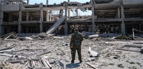 Ein ukrainischer Soldat betrachtet die durch einen russischen Angriff zerstörte Nationale Pädagogische Universität. Foto dpa