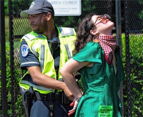 Eine Abtreibungsrechtsaktivistin wird festgenommen, nachdem sie rote Farbe auf den Bürgersteig vor dem Obersten Gerichtshof in Washington geworfen hat. Foto dpa