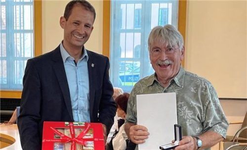 Georg Schmid (rechts) präsentiert das Ehrenzeichen, Oberbürgermeister Andreas März gratuliert.Foto Stadt Rosenheim