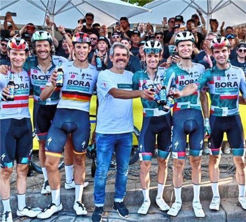 Ralph Denk (in weiß, Vierter von links) empfängt seine Tour-Mannschaft auf den Champs Élysées. Foto Bora-hansgrohe