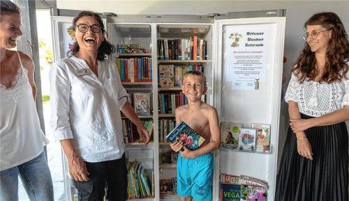 Sabrina Eickmann, Andrea Sondhauß und Jana Giebel (von links) vom Büchereiteam freuen sich bereits unmittelbar nach der Eröffnung des Bücherschranks über den ersten Leser, den neunjährigen Jonas Hellmann.