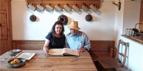 Archivarin Ingeborg Armbrüster und Eigentümer Konrad Walser beim Studieren der alten Gästebücher.