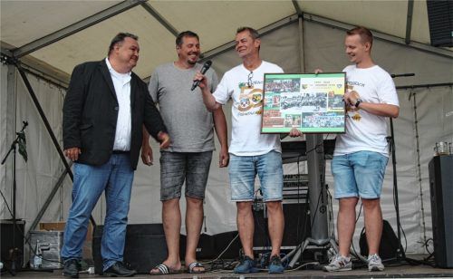 Bei der 50-Jahr-Feier zu Ehren der Freundschaft der beiden Fußballvereine wird eine Collage mit gemeinsamen Fotos überreicht. Auf dem Bild von links: Thomas Loose (1. Vorstand SpVgg), Klaus Alt (2. Vorstand SpVgg), Mike Schepanski (Organisator des Festes und Schriftführer des TuS), Tom Heinrich (1. Vorstand TuS). Foto Seitz