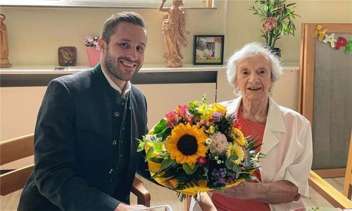 Bronislawa Plattner bekommt von Daniel Artmann, Zweiter Bürgermeister von Rosenheim, zum 100. Geburtstag einen Blumenstrauß überreicht. Foto Baumeister