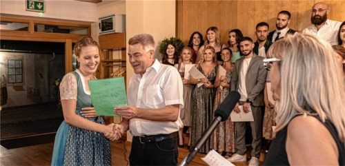 Eine strahlende Johanna Inninger empfängt von Stefan Mashold, dem Obermeister der Friseurinnung, die Glückwünsche zur Innungsbesten. Rechts im Bild Gitti Gaida, die stellvertretende Obermeisterin, im Hintergrund die anderen gerade freigesprochenen Friseurgesellen. Foto Thomae