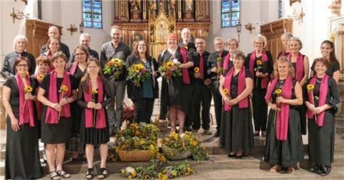 Große Blumensträuße zum Dank: (Mitte, von links) Wolfram Heinzmann, Christiane Drexler und Nadja Stübl, im Kreise der Chormitglieder.Foto re