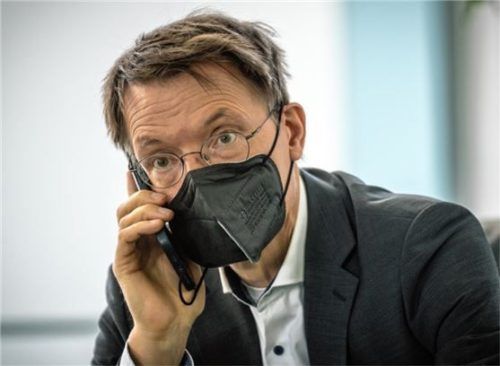 Karl Lauterbach (SPD), Bundesminister für Gesundheit, sitzt vor der Sitzung des Bundeskabinetts telefonierend mit Maske im Kanzleramt. Foto dpa