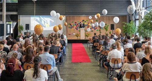 Über den roten Teppich schritten die Absolventen der Pauline-Thoma-Schule zum Abschied. Rektor Markus Rinner (am Rednerpult) wünschte sich, dass die Schulfamilie ihnen gute Weichen fürs weitere Leben gestellt hat. Foto  Re