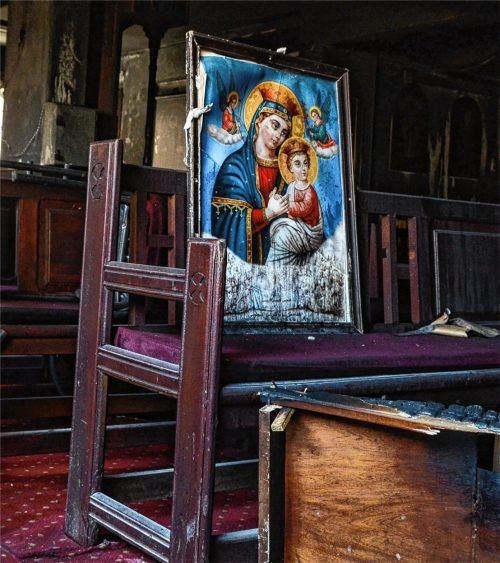 Zerstörte religiöse Bilder stehen auf einer Holzbank in der koptischen Abu-Sefein-Kirche, nachdem dort ein Großbrand ausgebrochen ist. Bei dem Brand im Großraum von Kairo sind mehrere Menschen ums Leben gekommen. Foto dpa