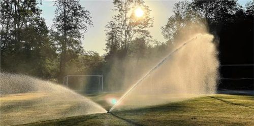 Bewässerung im Einsatz. Sie versprüht aufgefangenes Dachflächen- und Hangwasser.