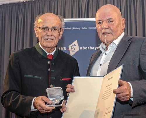 Bezirkstagspräsident Josef Mederer (links) verleiht die Bezirksmedaille an Sepp Hirle. Foto  Englmaier/ Bezirk Oberbayern