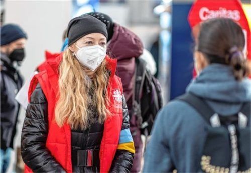 Eine Mitarbeiterin der Caritas verteilt am Münchner Hauptbahnhof an Flüchtlinge aus der Ukraine Essen und Getränke. Foto dpa